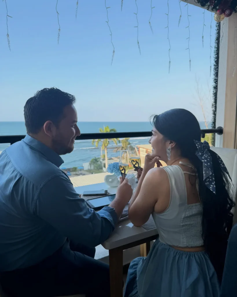 Pareja compartiendo una comida en un restaurante frente al mar en Manta