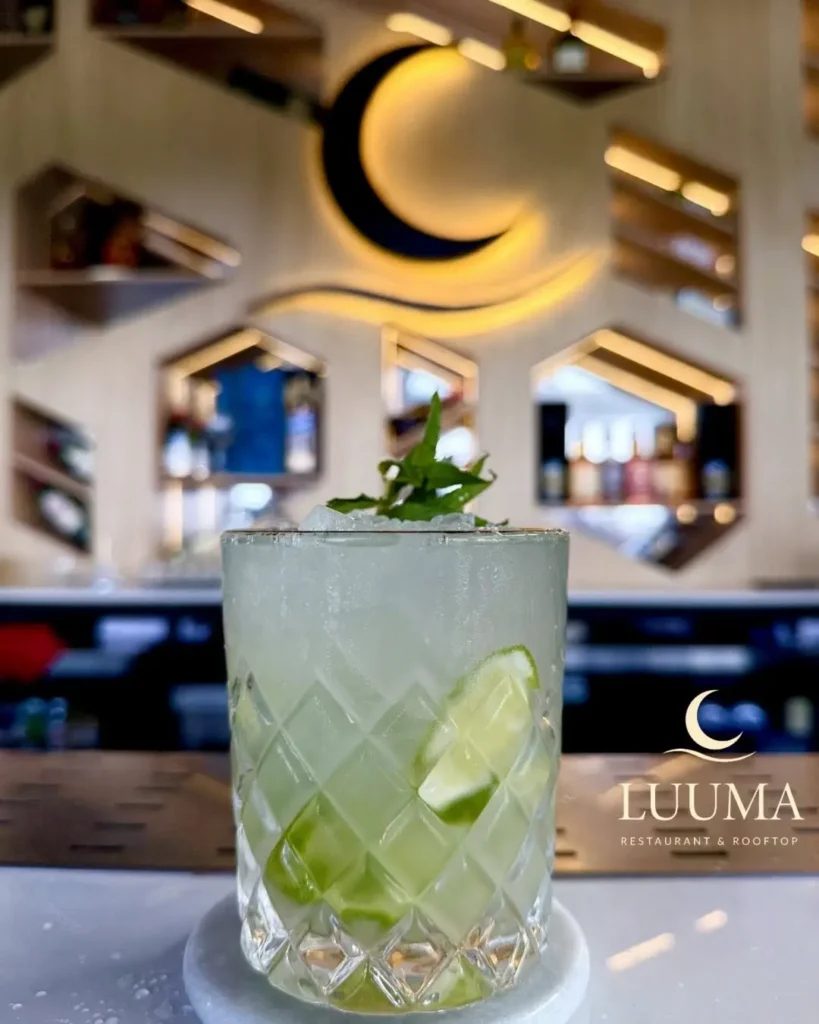 Cóctel servido en un rooftop bar en Ecuador con presentación elegante y ambiente panorámico