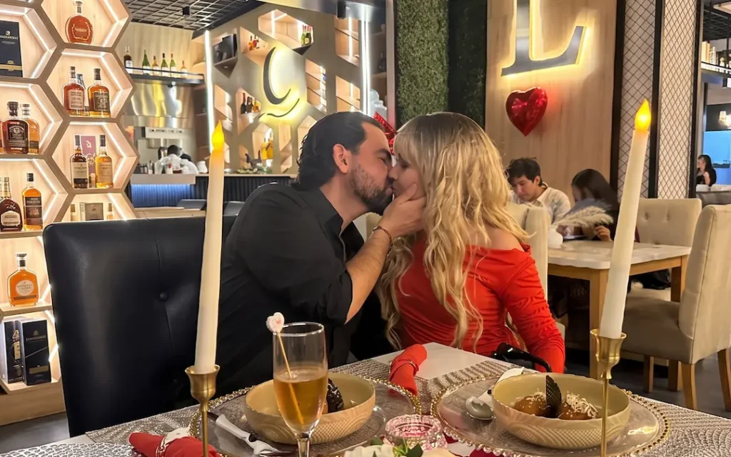 Cena romántica en Manta con mesa elegante, velas y vista al océano al atardecer.