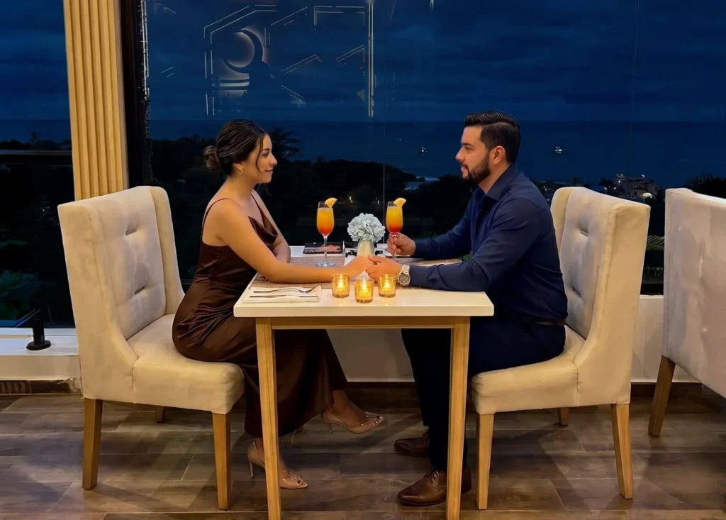 Pareja disfrutando una cena con vista al mar en un restaurante de Manta al atardecer