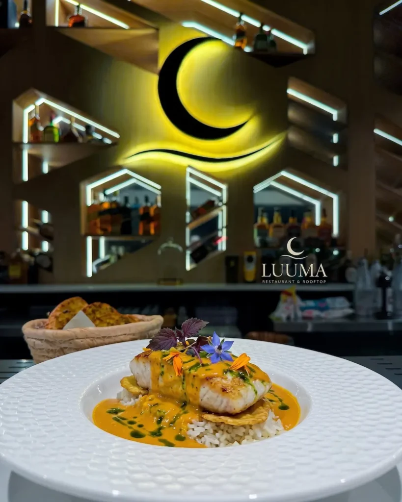 Encocado de pescado servido en Luuma Rooftop con presentación gourmet y acompañamientos