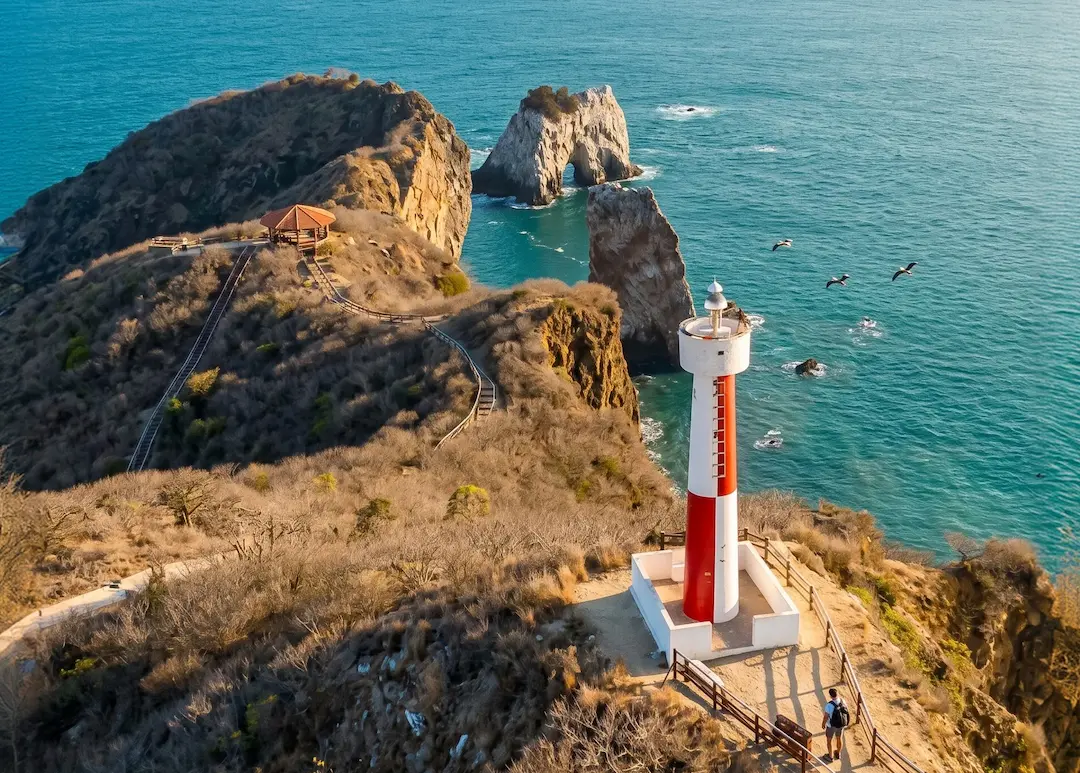 Faro de San Lorenzo en Manta con vista al océano y acantilados costeros.