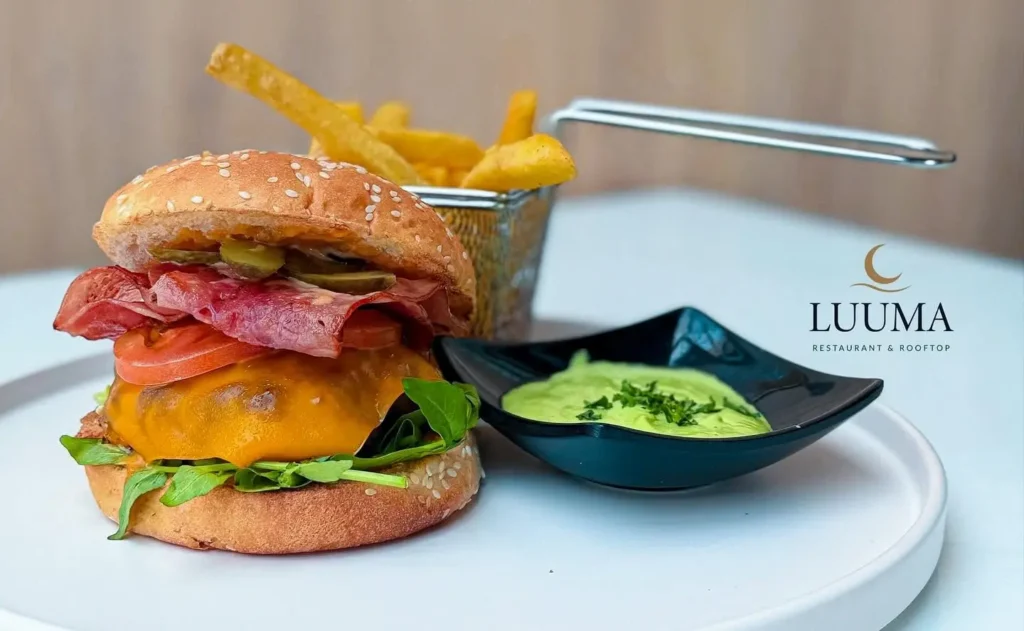 Hamburguesa gourmet servida en un restaurante de Manta con acompañamientos y presentación atractiva