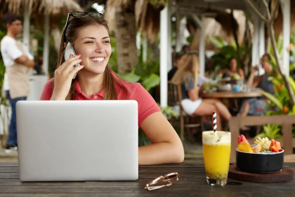 Nómadas digitales trabajando con computadoras portátiles en un espacio frente al mar