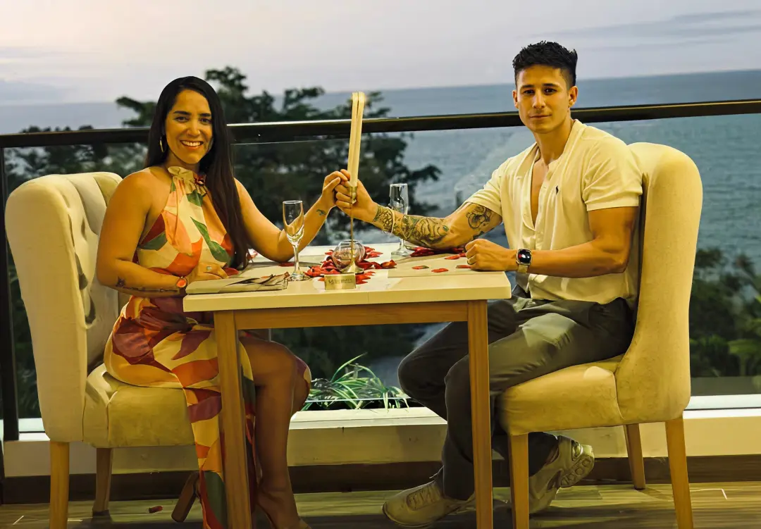 Pareja disfrutando una experiencia romántica junto al mar en Manta durante el atardecer