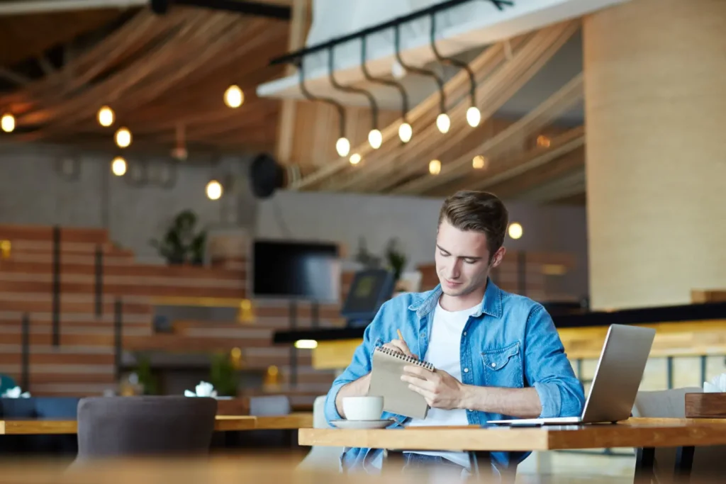 Persona trabajando con una computadora portátil en un restaurante de Manta con servicio de WiFi