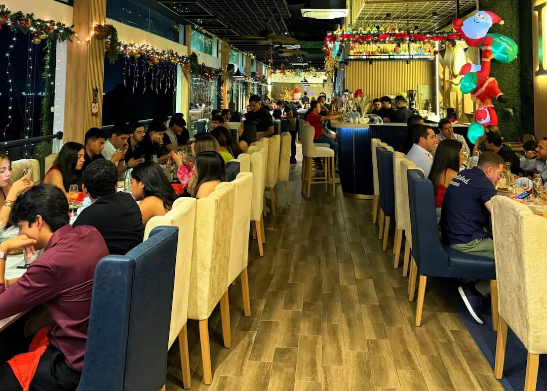 Grupo de personas compartiendo una comida en un restaurante de Manta con amplios espacios